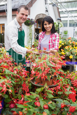 Smiling customer touching plant with employee