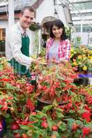 Smiling customer touching plant with employee