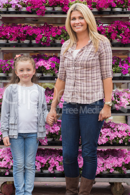 Mother and daughter holding hands in garden center