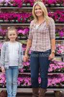 Mother and daughter holding hands in garden center