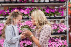 Mother and daughter smelling plant