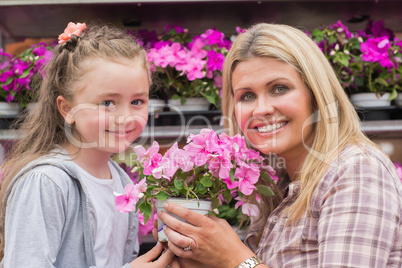 Mother and daughter holding a plant