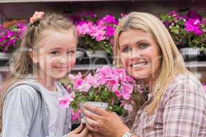 Mother and daughter holding a plant