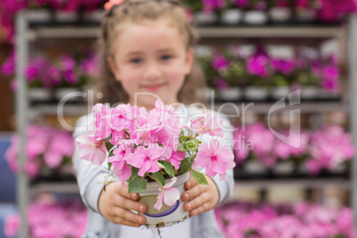 Little girl with flowers in garden center