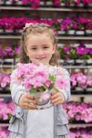 Little girl smiling and holding a flower pot