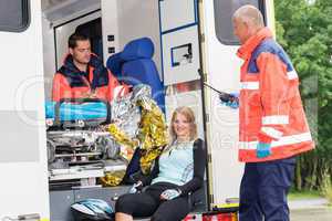 Woman in ambulance with paramedics aid accident