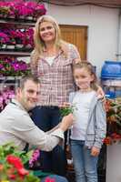 Mother and daughter receiving flower pot from employee