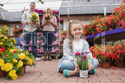 Family holding flower pots in garden center