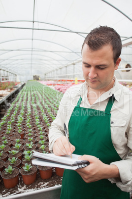 Greenhouse worker taking notes