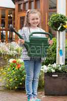 Little girl holding watering can while smiling