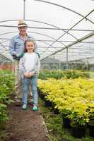 Gardener with granddaughter in greenhouse