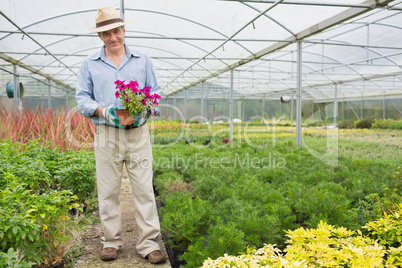 Smiling man holding a flower pot