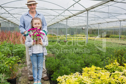 Gardener standing with granddaughter holding a flower pot