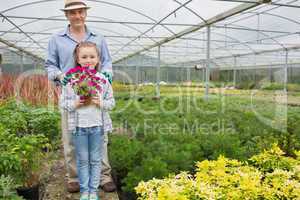 Gardener standing with granddaughter holding a flower pot