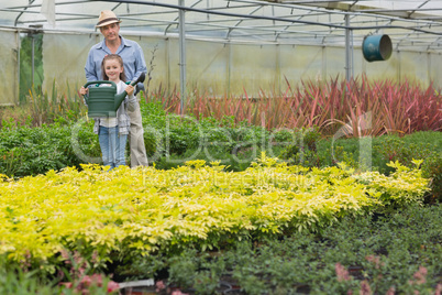 Gardener and grandchild holding a watering can