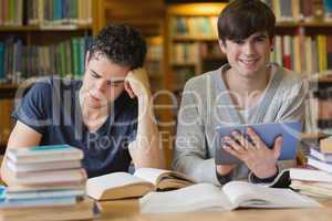 Young man with tablet pc in the library