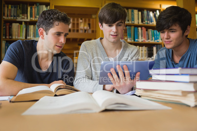 Men sitting at the library looking at tablet pc