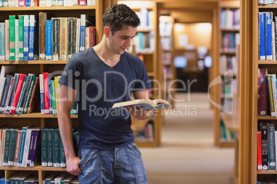 Man standing at the library holding a book