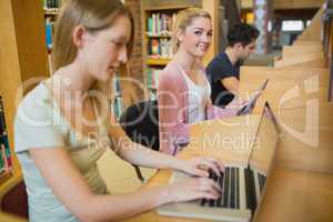 Woman using tablet pc looking up from studying