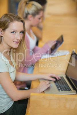 Woman using laptop looking up from studying