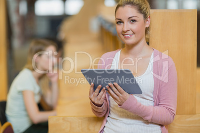 Woman standing in library with tablet pc