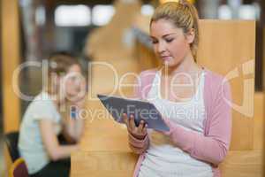 Woman using tablet standing in college library