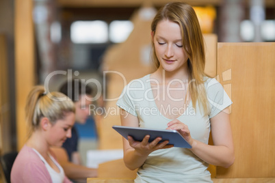 Woman standing holding a tablet pc at the library