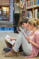 Students sitting on floor of library and studying