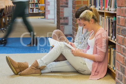 Students sitting in front of a bookshelf