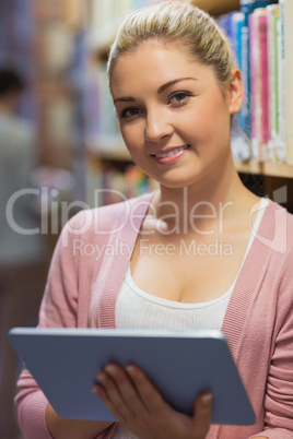 Woman standing at the library holding a tablet computer Woman standing at the library holding a tablet computer