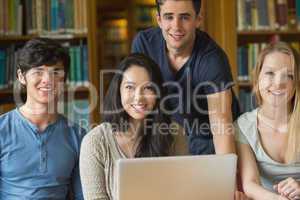 Students sitting at the library while smiling