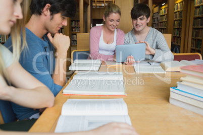 Students in the library studying with two using tablet pc