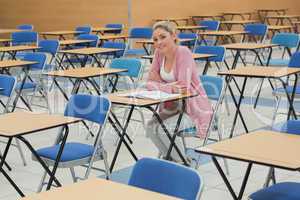 Student sitting at desk in empty exam hall