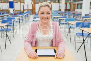 Student with tablet pc sitting in exam hall