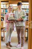 Couple standing at the library holding books