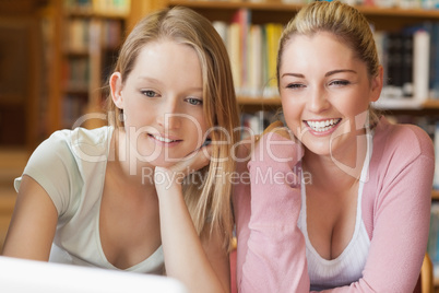 Friends sitting in library with laptop