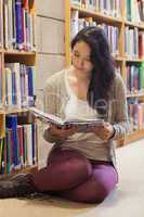 Woman sitting on library floor reading book