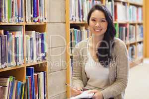 Woman sitting on the library floor smiling