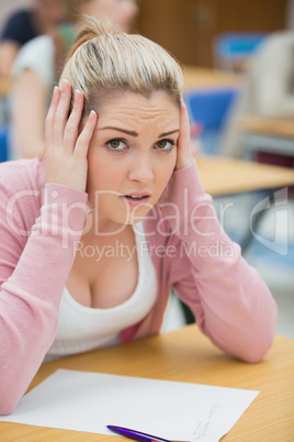 Worried student looking up from exam paper