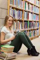 Girl sitting on the library floor holding a book