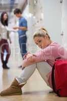 Student sitting on the floor at the hallway