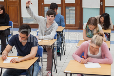 Boy raising hand during exam