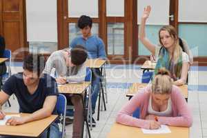 Woman raising hand during exam