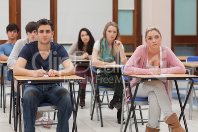 Students sitting at the classroom listening