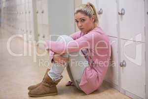 Upset girl sitting in hallway