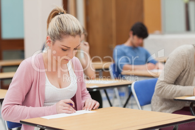 Woman writing note in classroom