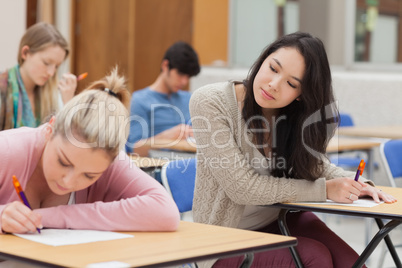 Girl copying another students work in exam