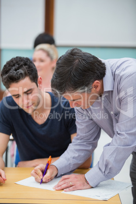 Teacher making note on students work