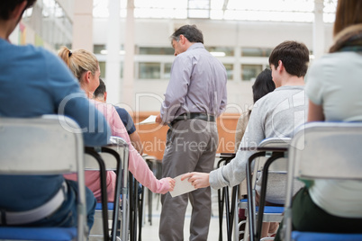 Students passing a note behind teacher's back