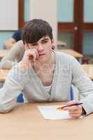 Student sitting at table thinking